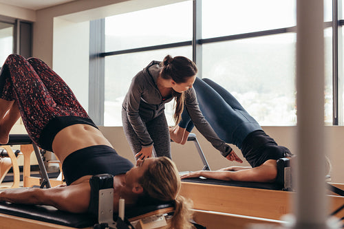 Pilates trainer instructing women at the gym