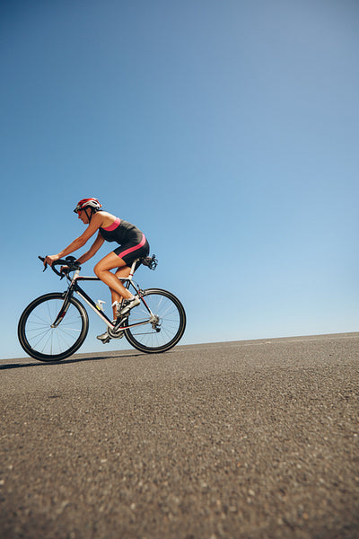 Female athlete training for cycling event of a triathlon
