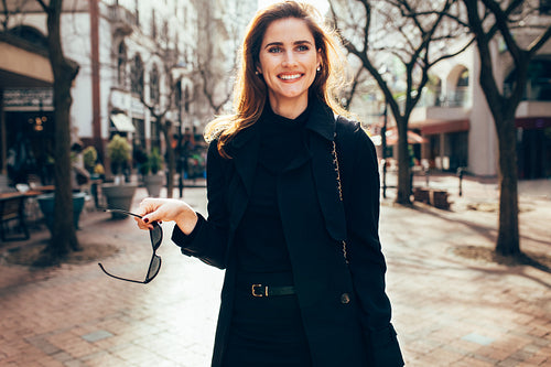 Stylish female with sunglasses walking on city street