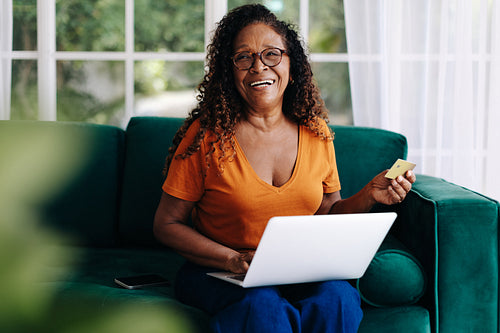 Retired woman buying from online stores using a gold credit card