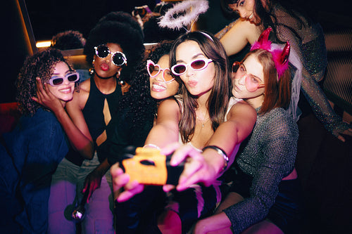 Friends enjoying a vibrant party night and posing together for a fun selfie