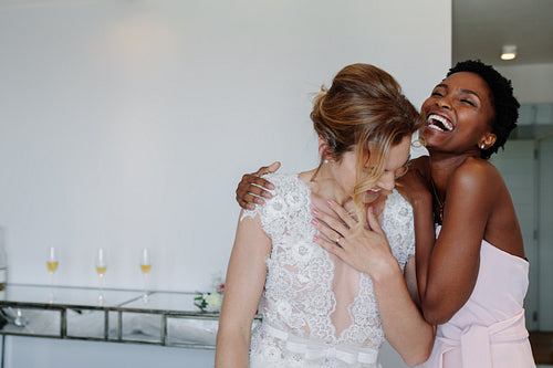 Bride and bridesmaid on the wedding day in hotel room