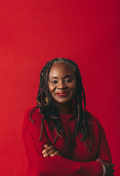 Portrait of a woman with dreadlocks looking at the camera in a studio