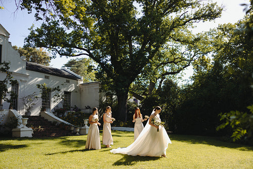 Elegant bridal party in a garden wedding setting under a large tree