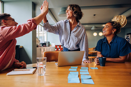 Three colleagues engaging in a lively meeting with ideas and teamwork