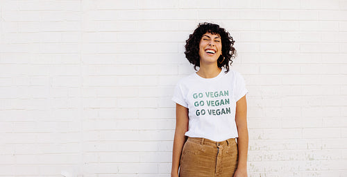 Happy young woman wearing a GO VEGAN shirt