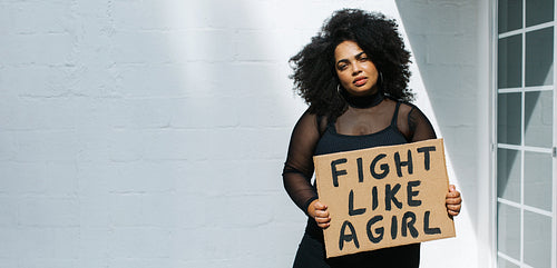 Beautiful woman with "Fight like a girl" placard