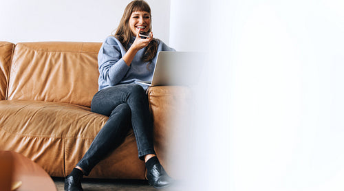 Happy businesswoman taking a phone call in an office lobby