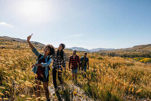 group of friends taking photograph on country walk