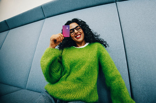 Indoors, the student uses a credit card for online shopping and budgeting