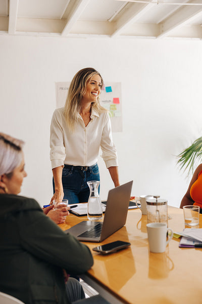Happy team leader having a meeting with her colleagues
