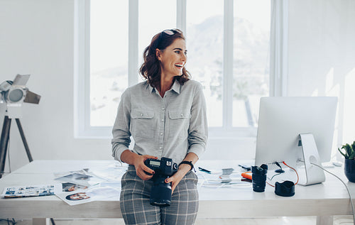 Cheerful woman photographer at office