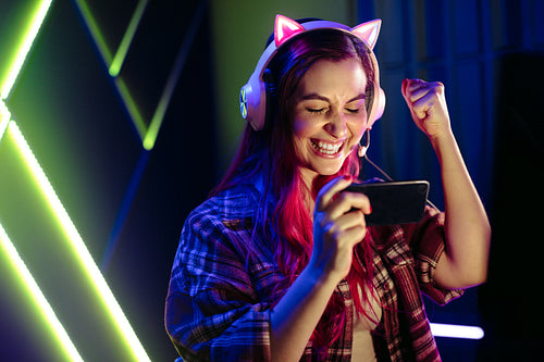 Victory! Female gamer celebrating winning a mobile phone