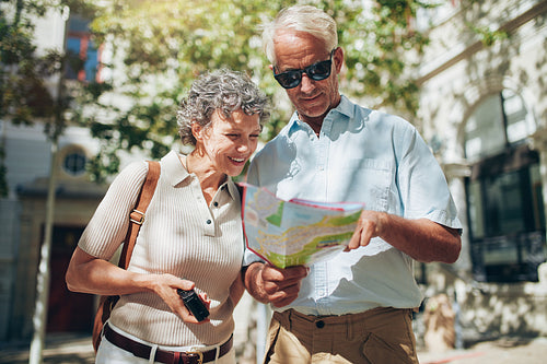 Senior couple looking at a map while sightseeing