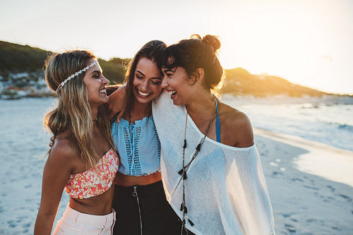 Stylish young women on beach at sunset