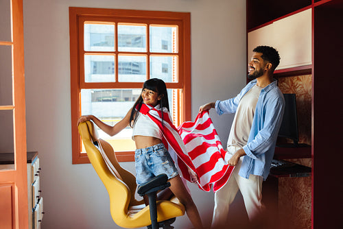 Father and daughter playing together in a sunny home environment