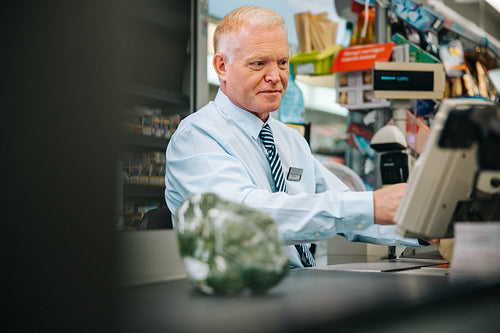 Senior cashier working at supermarket