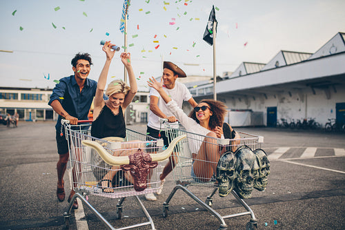 Young friends racing with shopping carts