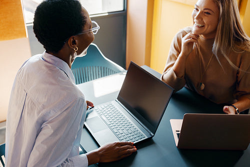 Freelancers collaborating on laptops in a bright modern workspace