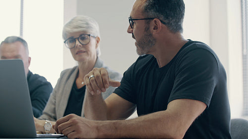 Businessman giving demonstrating on laptop to colleagues