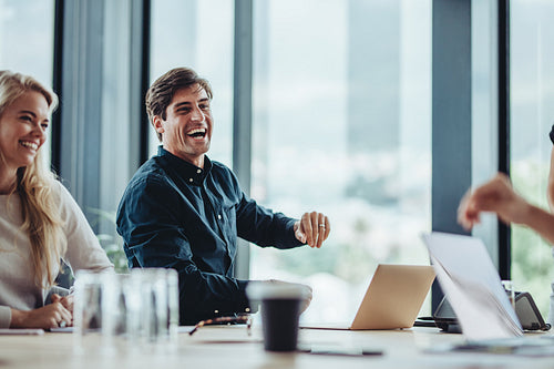 Cheerful businesspeople sitting in conference room