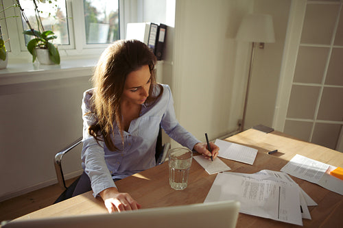 Young female writing notes from the internet