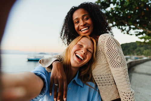 Two friends taking a joyful selfie on Urca’s Wall waterfront