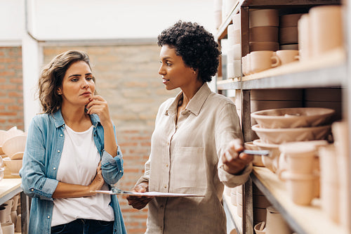 Two ceramic shop owners having a discussion in their store