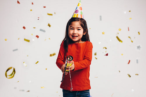 Kid holding a party popper