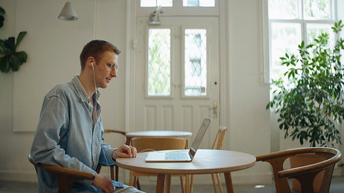 Man talks on a laptop video call at a casual desk workspace