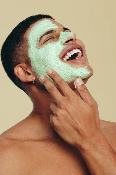Skin care with a hydrating face mask: Handsome young enjoying his beauty routine