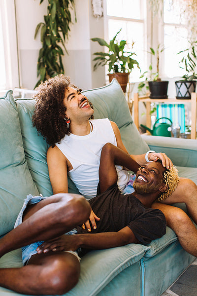 Carefree young gay couple relaxing on a couch