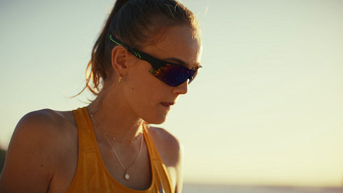 Close-up shot of a caucasian female beach volleyball player catching her breath