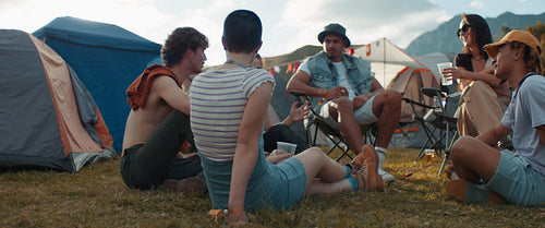 Friends cheering and toasting at a music festival campsite