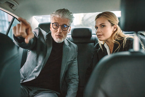 Two businesspeople traveling by car