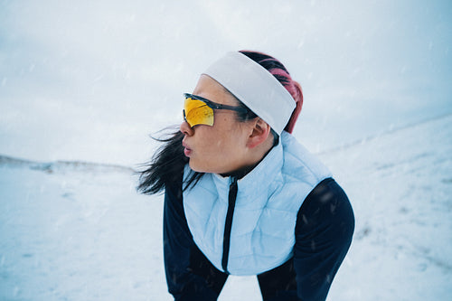 Recovery follows running as the woman catches her breath in winter snow