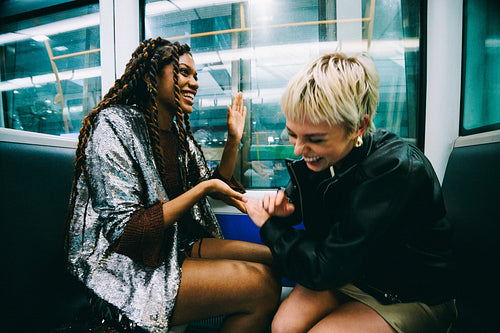Hand game on the metro: friends laughing on the ride