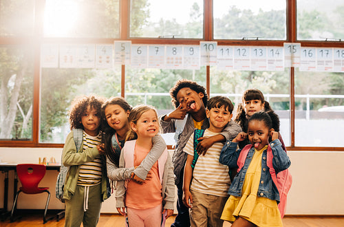 Back to school excitement. Group of primary school kids making funny faces and looking at the camera