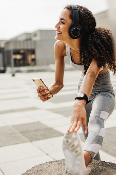 Woman exercising and listening to music outdoors