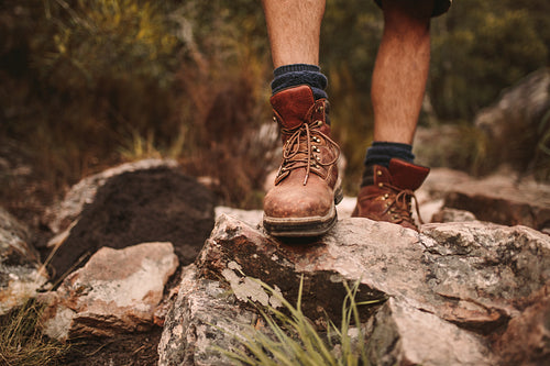 Man hiking through rocky path in trekking boots