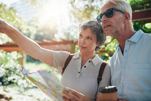 Couple holding a map and pointing away