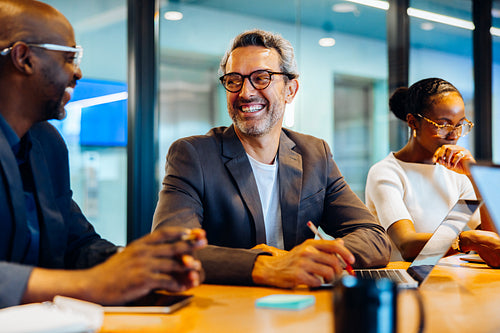 Business professionals talking and smiling during a meeting in a conference room