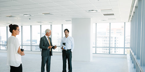 Real estate agent talking with clients inside an empty office space