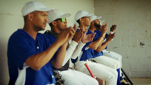 Baseball team applauds from the dugout bench