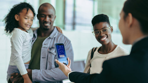Airline attendant checking digital boarding pass of passengers