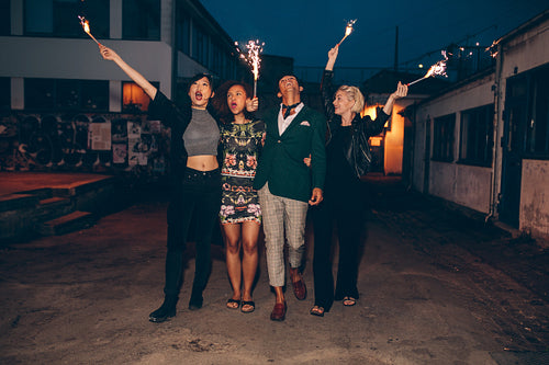 Friends enjoying out with sparklers on city street