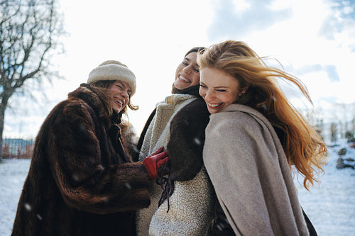 Close embrace brings women friends together in a snowy park