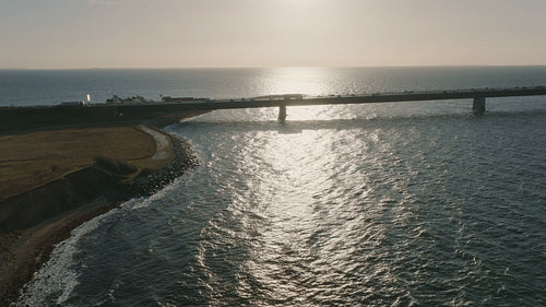 Journey across the Great Belt Bridge: View of traffic moving across Denmark's seaside at sunset
