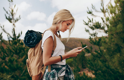 Side view of a woman traveller looking at her mobile phone