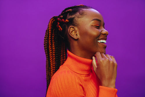 Colorful two tone braids on confident woman against purple background